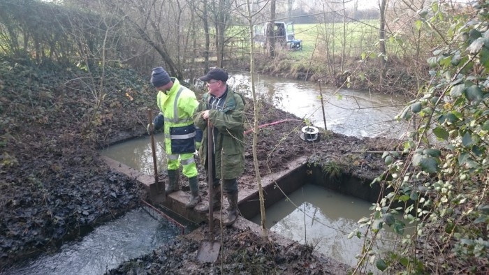 deux personnes surveillent l'écoulement de l'eau